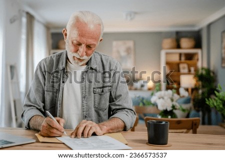 senior caucasian man open mail letter sign document envelope while sit at the table at home receiving bank statement loan approval contract or business insurance news invitation Royalty-Free Stock Photo #2366573537
