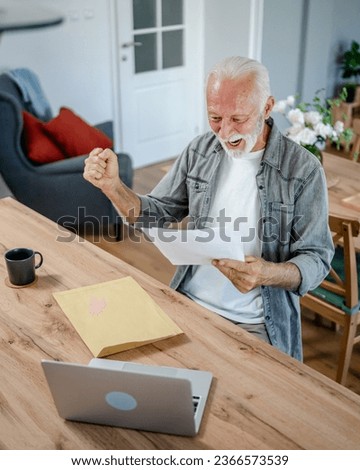 senior caucasian man open mail letter or document envelope while sit at the table at home receiving bank statement loan approval contract or business insurance news invitation Royalty-Free Stock Photo #2366573539