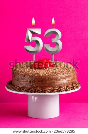 Number 53 candle - Chocolate cake on pink background
