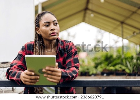 Portrait of of smiling happy african woman relaxing use technology of tablet at home.Young african creative girl looking at screen typing message and playing game online or social media