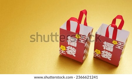 The characters for "Lucky bag" are written in Japanese.Gold background.Japanese lucky bag.An image of Japanese New Year. Royalty-Free Stock Photo #2366621241