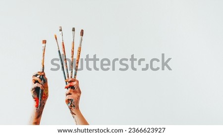 Artist equipment. Painting brush. Woman painter hands holding set of messy colorful paintbrushes isolated on white empty space background. Royalty-Free Stock Photo #2366623927
