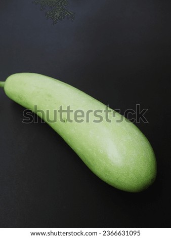 Light green zucchini on a black background