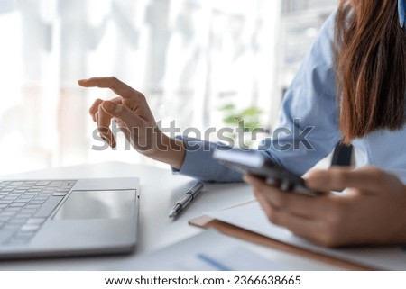 Happy young asian female accountant Positive concept using smartphone at her desk to relax with mobile application and use to chat business contact online marketing Excellent profit.