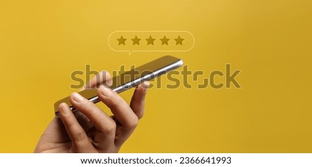 Customer Experiences Concept. Happy Client Using Smartphone to Submit Five Star Review Rating for Online Satisfaction Surveys. Positive Feedback on Mobile Phone