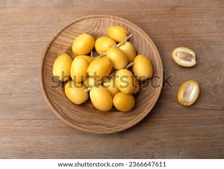 top view and flat lay appetizing a Group fruit of fresh palm phoenix dactylifera or date palm fruit in a plate on a wooden background 
 Royalty-Free Stock Photo #2366647611
