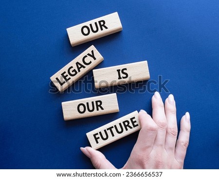 Our Legacy is our Future symbol. Concept words Our Legacy is our Future on wooden blocks. Businessman hand. Beautiful deep blue background. Business  concept. Copy space
