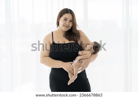 Asian young mother embrancing and carrying her newborn baby on white background. Happy Asian newborn baby and Asian young mother. family, love, happy and new life concept