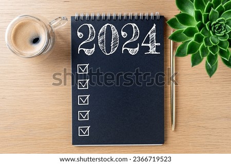 New year resolutions 2024 on desk. 2024 resolutions list with notebook, coffee cup on table. Goals, resolutions, plan, action, checklist concept. New Year 2024 template, copy space Royalty-Free Stock Photo #2366719523