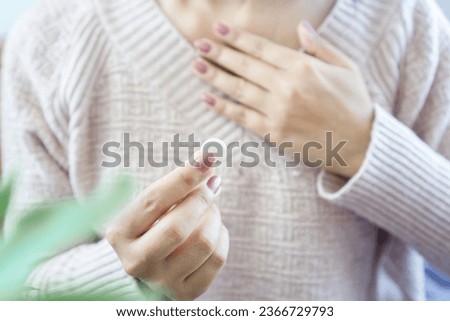 woman having problem with heartburn from acid reflux disease hand taking antacid medicine for GERD treatment  Royalty-Free Stock Photo #2366729793