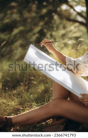 Pretty woman paints picture outdoors canvas lifestyle. High quality photo