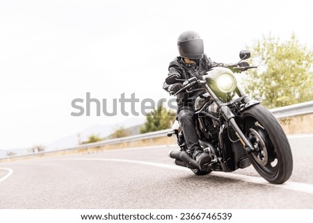High key shot of a man riding a chopper motorbike on an open road Royalty-Free Stock Photo #2366746539