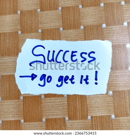Motivation Quote "SUCCESS Go Get It!" Written on White Paper with Blue Color Pen, Brown Background