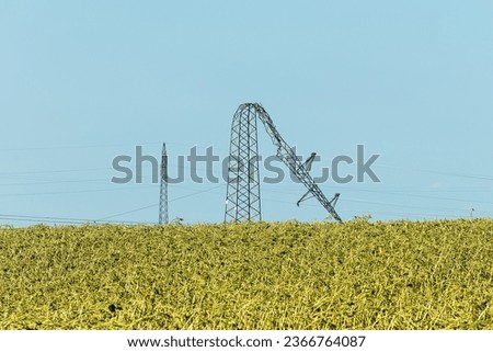 Bent over electricity pylon after strong summer storm, climate change consequences Royalty-Free Stock Photo #2366764087