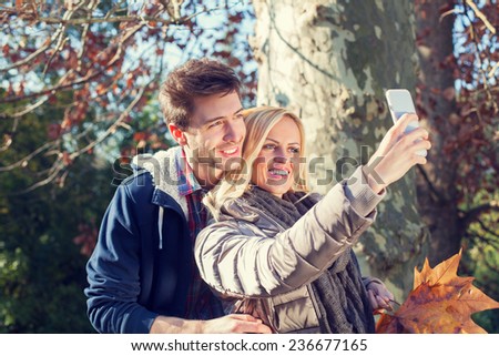 Couple taking Selfie in autumn in a forest