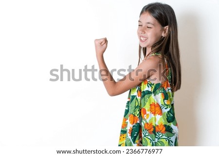 Portrait of funny young beautiful kid girl shout yeah raise fists hands celebrate victory game competition