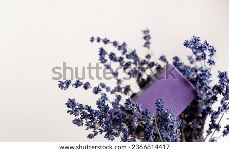 lavender handmade soap isolated on light background, on bed sheet with flowers and purple sack for sleeping improvement.soap on woman hand, woman holding bouquet.minimalist product photography. Royalty-Free Stock Photo #2366814417