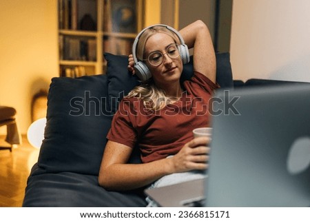 Woman is enjoying a late night movie on laptop.