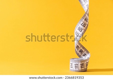 colorful measuring tapes top view on bright yellow background