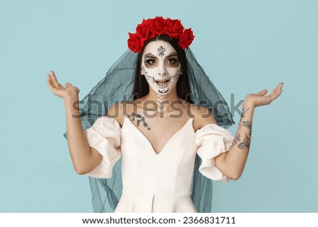 Beautiful shocked young woman dressed as dead bride for Halloween party on blue background