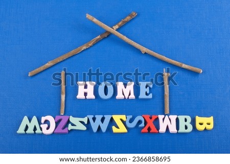 HOME word on blue background composed from colorful abc alphabet block wooden letters, copy space for ad text. Learning english concept