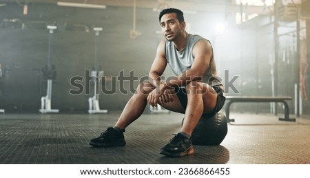 Fitness, breathing and sweating with a tired man in the gym, resting after an intense workout. Exercise, health and fatigue with a young athlete in recovery from training for sports or wellness Royalty-Free Stock Photo #2366866455