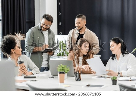 multiethnic business team generating ideas and discussing project in coworking, group of people Royalty-Free Stock Photo #2366871105