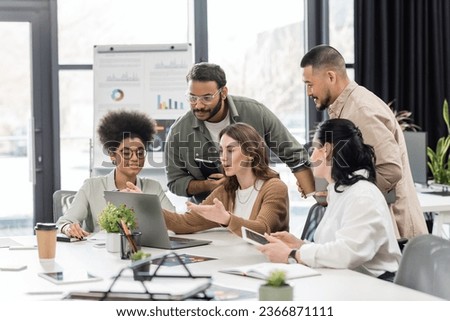 candid photo, interracial business team discussing project and sharing ideas in modern coworking Royalty-Free Stock Photo #2366871111