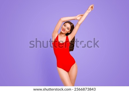 It is pool party time Charming brunette in red swimsuits with hands up having fun stand isolated on vivid yellow background