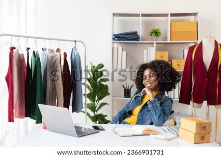 African American girl presents and sells clothes online through live streaming on the internet, chooses a stylish clothing store. Fashion designers draw pictures of new collections.
