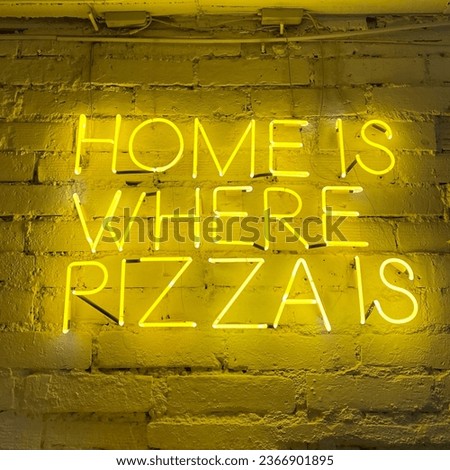 Photo of a neon sign glowing in the dark, with a humorous phrase in an Italian restaurant “home is where pizza is”