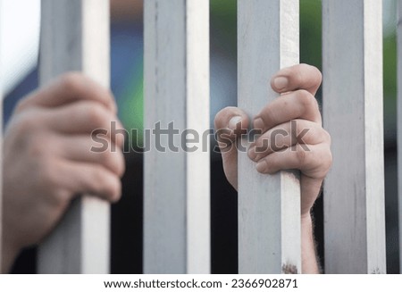prisoner looking out of the window of a prison cell Royalty-Free Stock Photo #2366902871