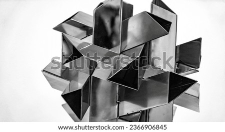 Abstract Photo of a metal shiny geometric real life object with triangle prisms intersecting in a 3d style