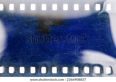 Dusty and grungy 35mm film texture or surface. Perforated scratched camera film isolated on white background. Royalty-Free Stock Photo #2366908837