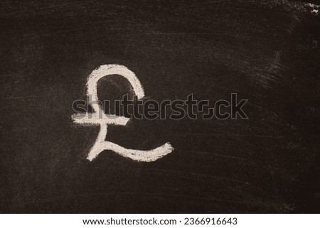 The sign of the franc, pound sterling written in chalk on a wooden board with space for text.