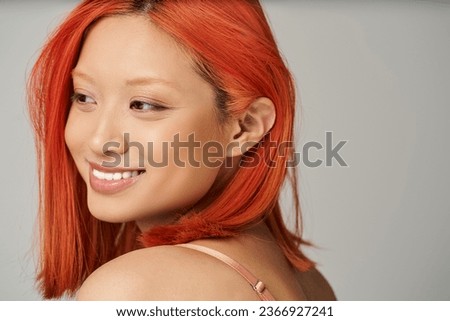 charming young asian woman with perfect skin and natural makeup smiling on grey background Royalty-Free Stock Photo #2366927241
