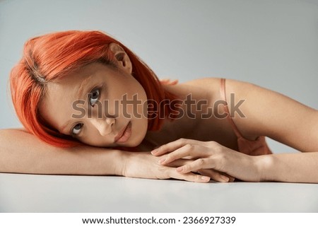 young asian woman posing and looking at camera on grey background, sophistication and grace