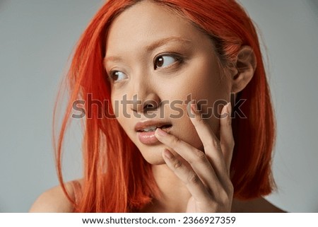 asian beauty, young woman with red hair and natural makeup looking away and touching cheek Royalty-Free Stock Photo #2366927359