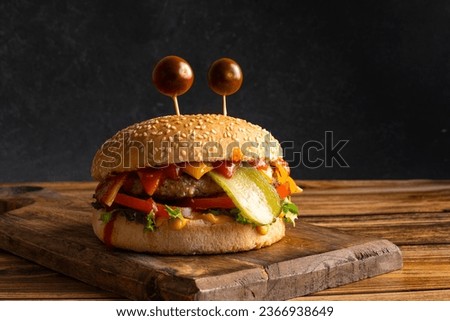 Halloween funny Monster cheeseburger on the wooden background