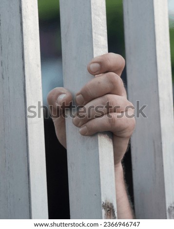 prisoner looking out of the window of a prison cell Royalty-Free Stock Photo #2366946747