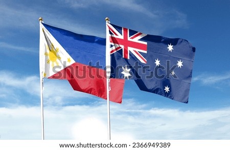 Australian flag and Philippine flag waving under cloudy sky. fluttering in the sky
