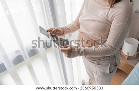 Pregnant asian woman holding  ultrasound baby Image Result from Doctor. Happy mom health care concept.