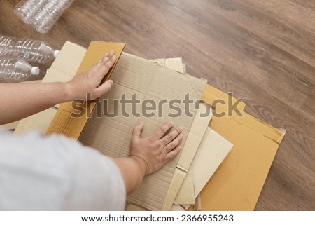 Home recycle eco zero waste concept Man using recycle paper box. Stacking brown cardboard box eco friendly packaging made of recyclable raw materials