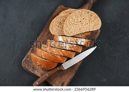 Sliced rye bread on cutting board. Whole grain rye bread  Royalty-Free Stock Photo #2366956289