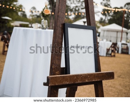 "Private Event" signage with party lights in the background.