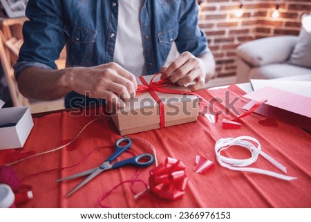 Cropped image of handsome romantic guy making present for his better half