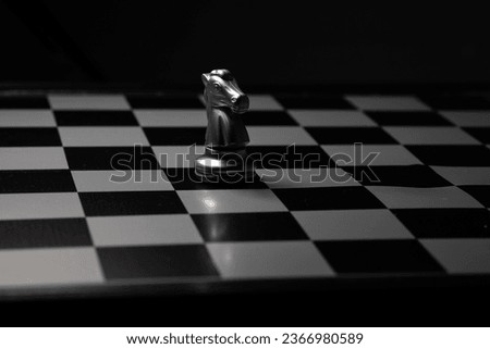 Silver knight Chess Placed on a chess board in a dark room. For creating business-related content