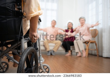 Close-up of senior woman in wheelchair with her caregiver in background and elderly friends are waiting to welcome