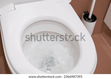 flushing water in toilet to demonstrate personal hygiene act, process of flushing water, clean and well-maintained toilet, associated with maintaining cleanliness in bathroom Royalty-Free Stock Photo #2366987395