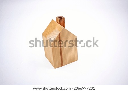 Small one-storey house model made of wood. Photograph.